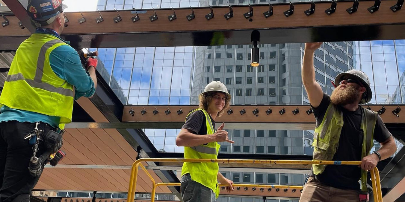 Male metalwork installation team members wearing full safety gears onsite