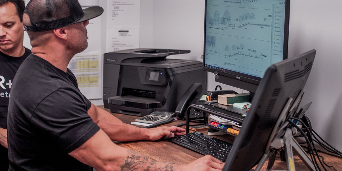 Engineer designing a conservation park bridge pre-construction drawing on desktop computer