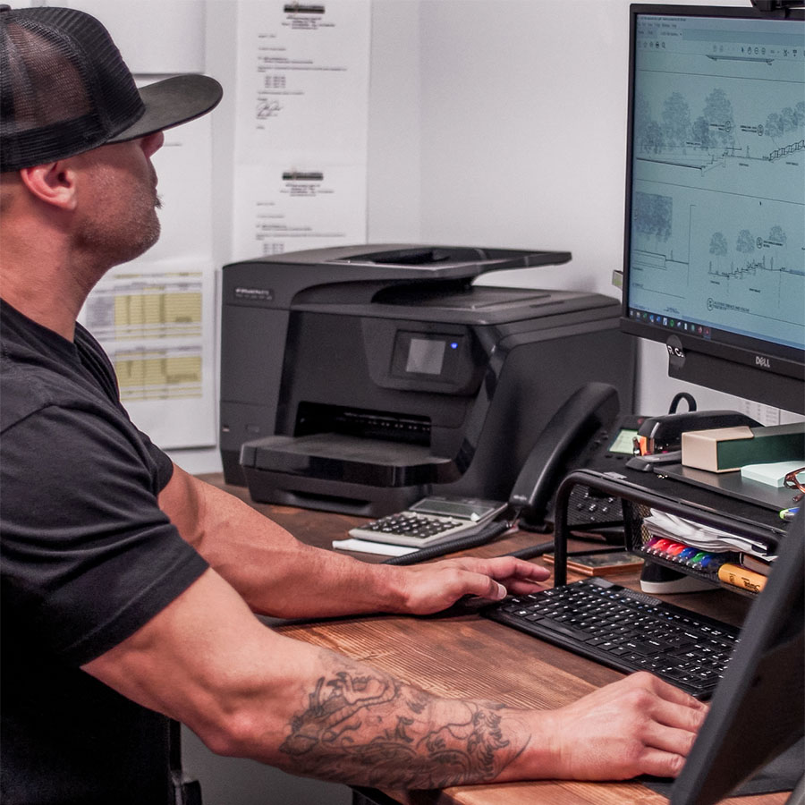 Engineer in black rendering construction design on desktop computer