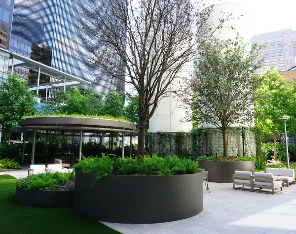 Renfrow+Co's pavilion at 1001 Fannin, featuring circular steel structures and custom planters, set amid lush greenery in downtown Houston
