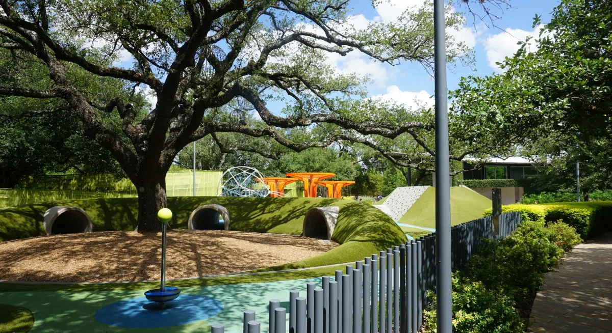 Colorful and playful space at Levy Park featuring unique orange play structures installed by Renfrow+Co